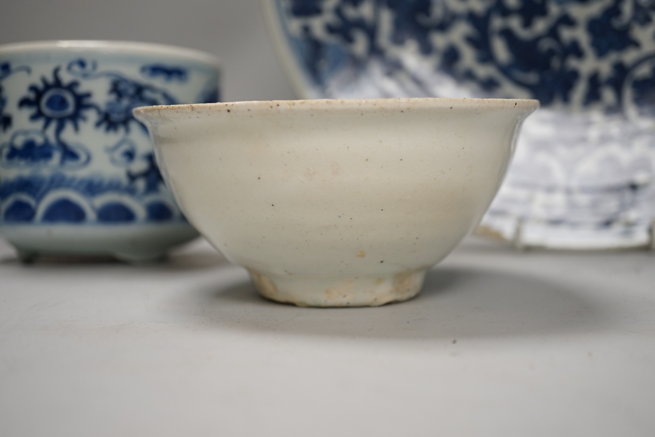 A Chinese blue and white ‘lotus’ charger, together with a bowl and dragon pot on tripod base